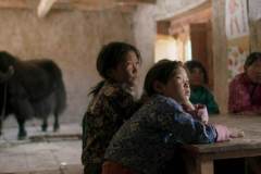 Lunana: Il vilaggio alla fine del mondo: la piccola Pem Zam coi suoi compagni e lo yak in una scena del film